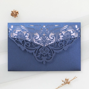 Detail of navy blue pearlescent paper envelope with laser-cut lace floral patterns