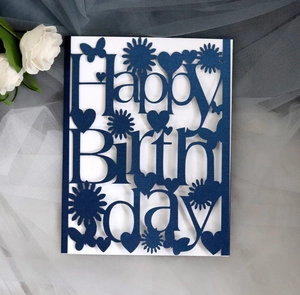 Detail of laser-cut Happy Birthday card in dark blue paper with floral and butterfly patterns