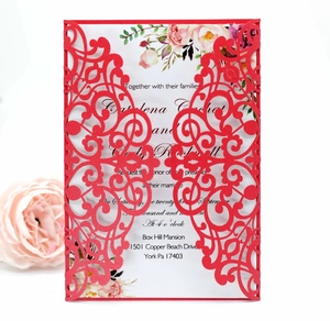 Close-up of laser cut hollow wedding invitation with red cover and floral insert