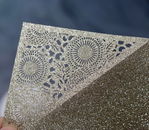 Golden glitter wedding invitation card with laser cut floral patterns and sparkling finish