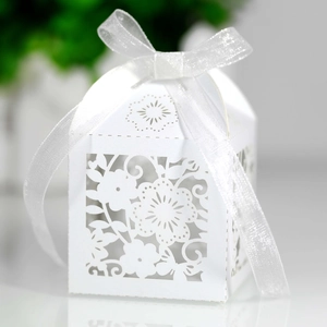 Detailed macro view of white laser-cut floral gift box with an elegant ribbon bow