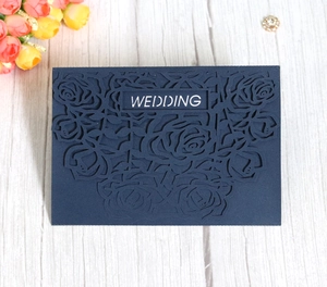 Close-up of laser-cut rose hollow design on navy blue wedding invitation card
