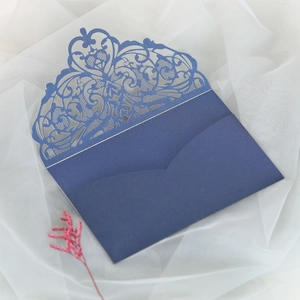 Close-up of laser-cut floral lace detail on navy blue pearlescent wedding invitation
