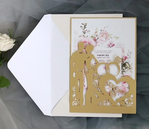 Detail of laser-cut gold wedding invitation with Mr & Mrs silhouette and floral inner card