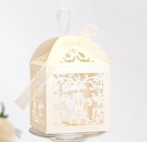 Macro detail of laser-cut vine pattern on cream pearl paper wedding favor gift box