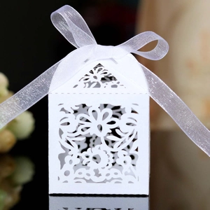 White laser cut wedding candy box with floral patterns and a white organza ribbon bow