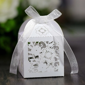 Detail of white laser-cut floral paper gift box with an organza ribbon bow decoration