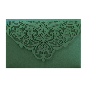 Detail of dark green pearlescent laser cut lace invitation with intricate floral patterns