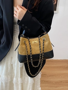 Quilted bucket bag with chain strap and gold hardware shown on a model’s shoulder