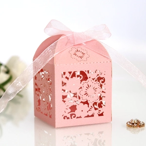 Close-up of pink laser-cut flower gift box with elegant satin ribbon bow and macro detail