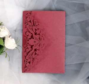 Macro detail of laser-cut lace pattern on burgundy glitter paper invitation card cover