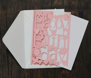 Laser-cut Happy Birthday greeting card in light pink with white envelope and heart detail
