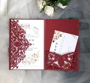 Detailed laser-cut vine patterns on burgundy wedding invitation envelopes with RSVP card