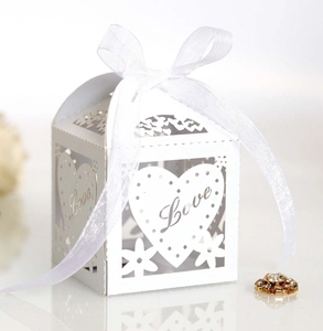 Detail of white laser-cut favor box with Love lettering and elegant organza ribbon