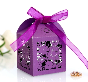 Macro shot of purple laser-cut flower patterns and organza ribbon on gift box