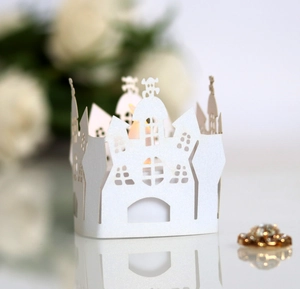 White laser cut castle paper candle wrap with warm glowing light for wedding decor