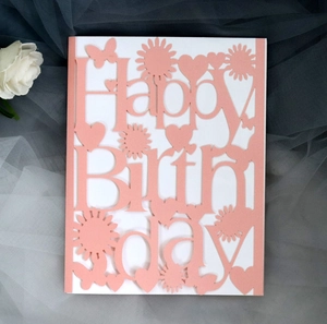 Detail of pink laser-cut Happy Birthday card with intricate butterfly and floral patterns