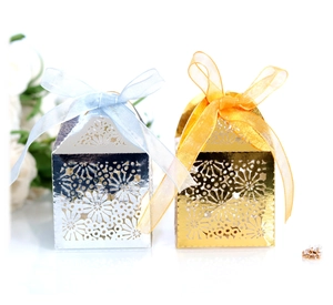 Detail lasergeschnittener Blumen-Süßigkeitenschachteln mit Satinbändern in Gold und Silber