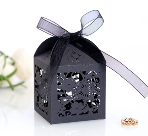 Detail of black laser-cut floral gift box with translucent chiffon ribbon and bow