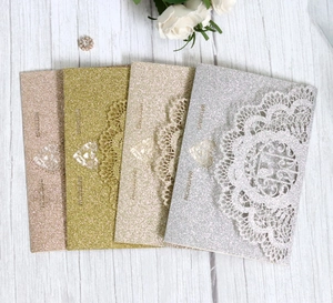 Detail of glitter laser-cut wedding invitations in rose gold, champagne, gold and silver