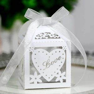Close-up of white paper candy box with heart cutout and delicate Love lettering