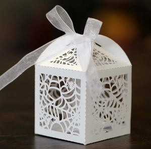 Macro shot of white laser-cut spider web gift box with elegant organza ribbon bow
