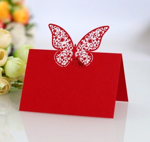 Detailed laser-cut red butterfly table card with elegant floral hollow patterns for weddings