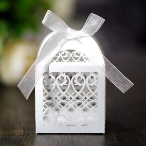Detailed laser-cut pattern on white wedding favor box with a silk ribbon bow