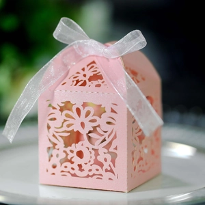 Detailed laser-cut pink wedding favor box with floral patterns and a white ribbon bow