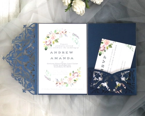 Macro view of laser-cut navy blue lace invitation set with floral card and RSVP details