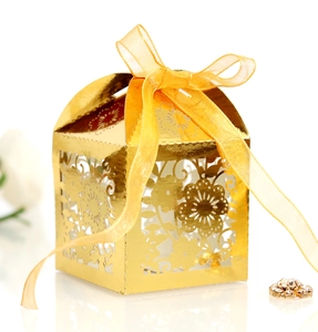 Detailed laser-cut gold floral favor box with yellow silk ribbon and mirror finish