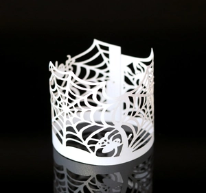 Macro view of white laser-cut spider web paper wraps for Halloween LED tea light candles