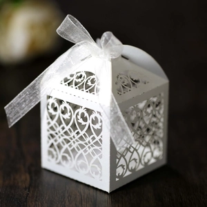 Detailed laser-cut pattern on white pearlescent candy box with white organza ribbon bow