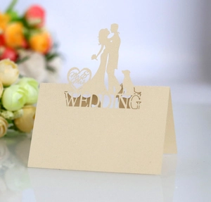 Detail of laser-cut heart wedding place card with Mr & Mrs silhouette and intricate patterns