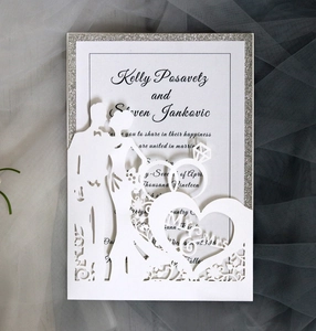 Detail of laser-cut wedding invitation featuring a couple silhouette and silver glitter frame