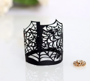 Close-up of laser-cut black spider web paper wrap with intricate hollow patterns