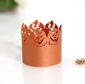 Laser-cut bronze hollow paper cupcake wrapper featuring Halloween jack-o'-lantern details