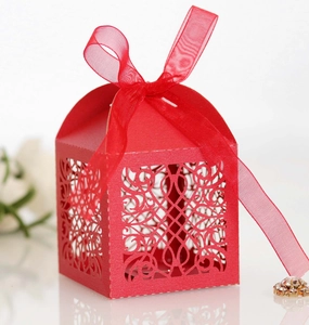 Macro shot of red laser-cut candy box featuring elegant floral patterns and ribbon