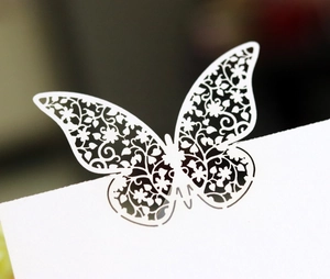Elegant white laser-cut butterfly place card with intricate floral hollow pattern