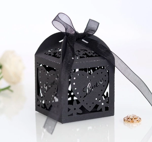 Detail of laser-cut black favor box with heart pattern, Love text and organza ribbon