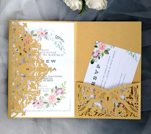 Macro shot of laser-cut gold glitter wedding invitation with floral lace and RSVP card