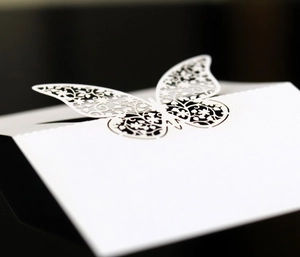 Laser-cut white butterfly place cards with elegant hollow patterns for wedding decor