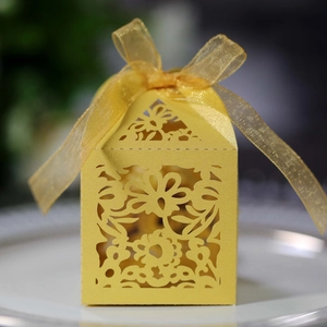 Detailed laser-cut floral patterns on a bright yellow gift box with organza ribbon bow
