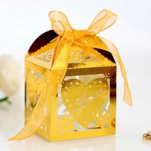 Close-up of golden hollow candy box with heart Love laser cut and yellow ribbon