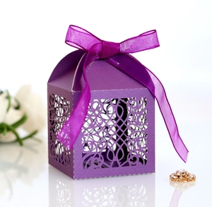 Detail of purple laser-cut wedding favor box with silk ribbon and floral patterns
