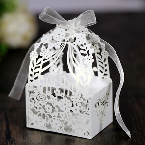 Detailed laser-cut wedding favor box with floral patterns and a silver ribbon bow