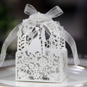 Close-up of laser-cut wedding candy box with bride and groom silhouette and ribbon