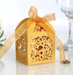 Detail showing gold laser-cut floral patterns and orange organza ribbon on candy box