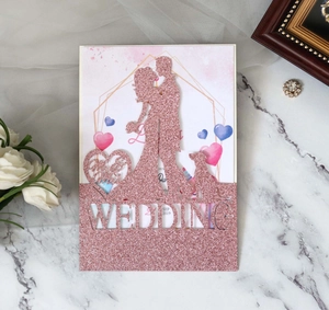 Detailed laser-cut glitter wedding invitation with heart patterns and elegant silhouettes