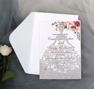 Détail d'une invitation de mariage argentée découpée au laser avec motifs floraux